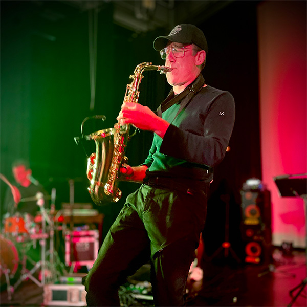 Serge Logie, saxofonist, speelt een saxsolo met zijn ogen gesloten op zijn alt-saxofoon.