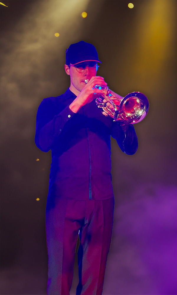 Jonas Dekyvere, trompetist, belicht door veel paars en gouden licht.